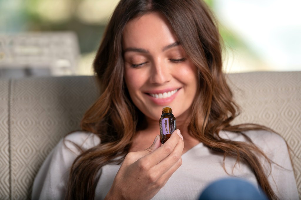 A woman holding a bottle of essential oil￼